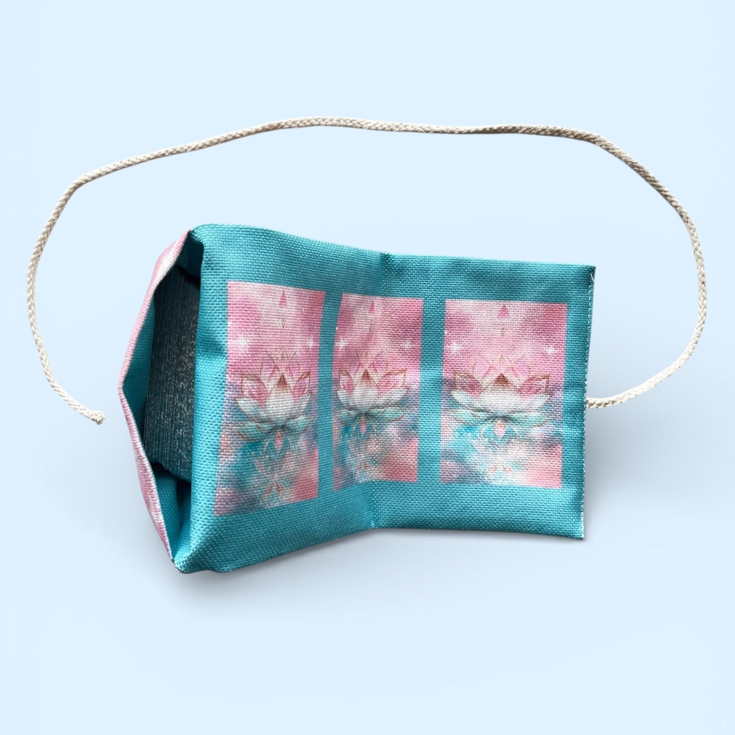 Fabric face mask with a pink floral design on a light blue background
